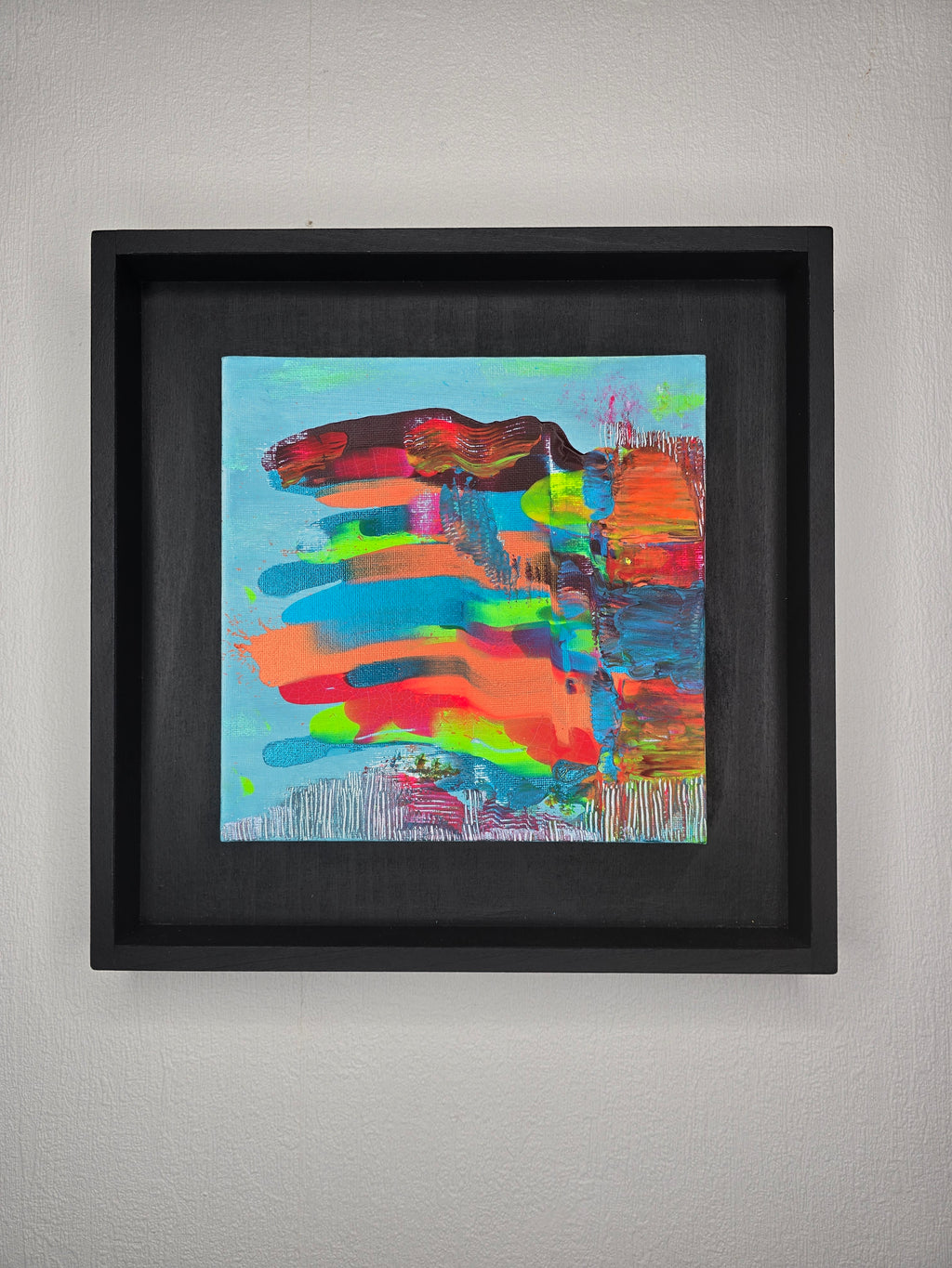 Petit tableau peinture abstrait carré Écrin Néon™ aux couleurs turquoise orange rose et bleu avec cadre noir contemporain