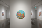 tableau abstrait coloré rond exposé dans une galerie
