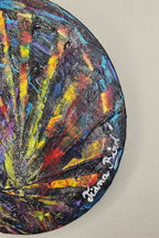 Gros plan sur un tableau abstrait rond coloré avec couleurs vives et effet d’explosion artistique